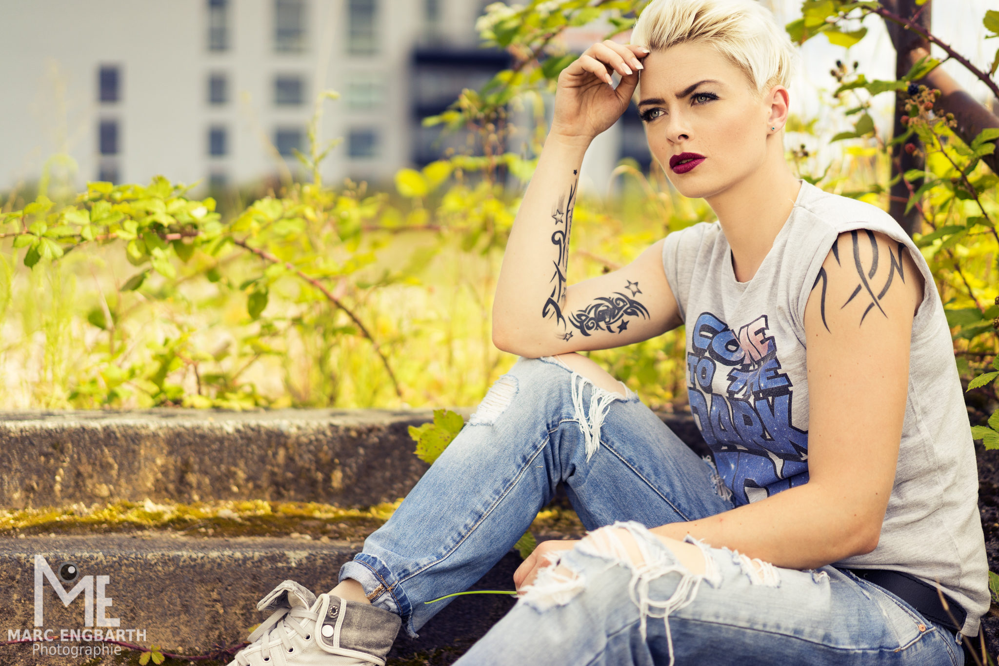 Frau mit Tattoos sitzt auf Treppenstufen