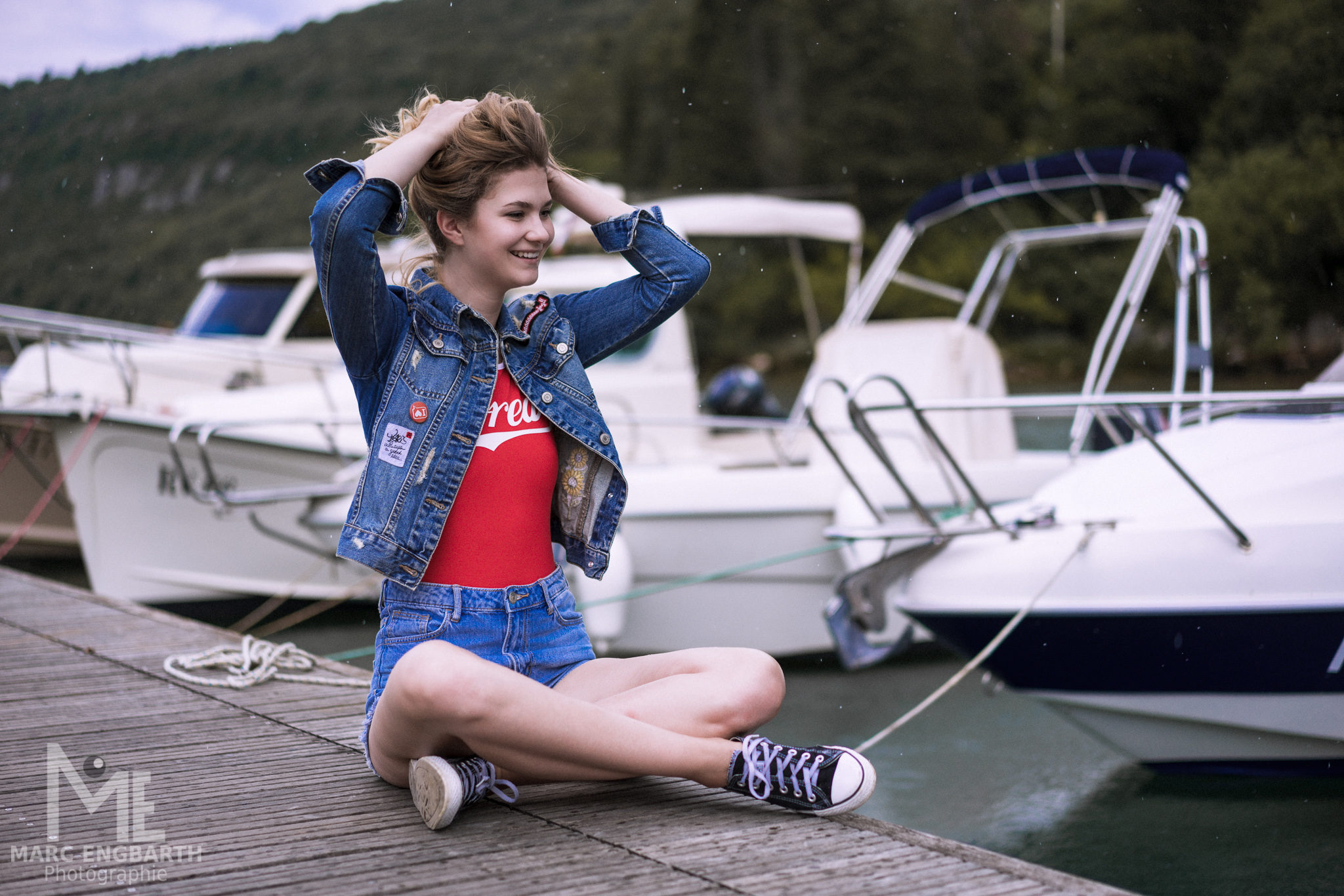 Frau in Jeansjacke am Bootssteg