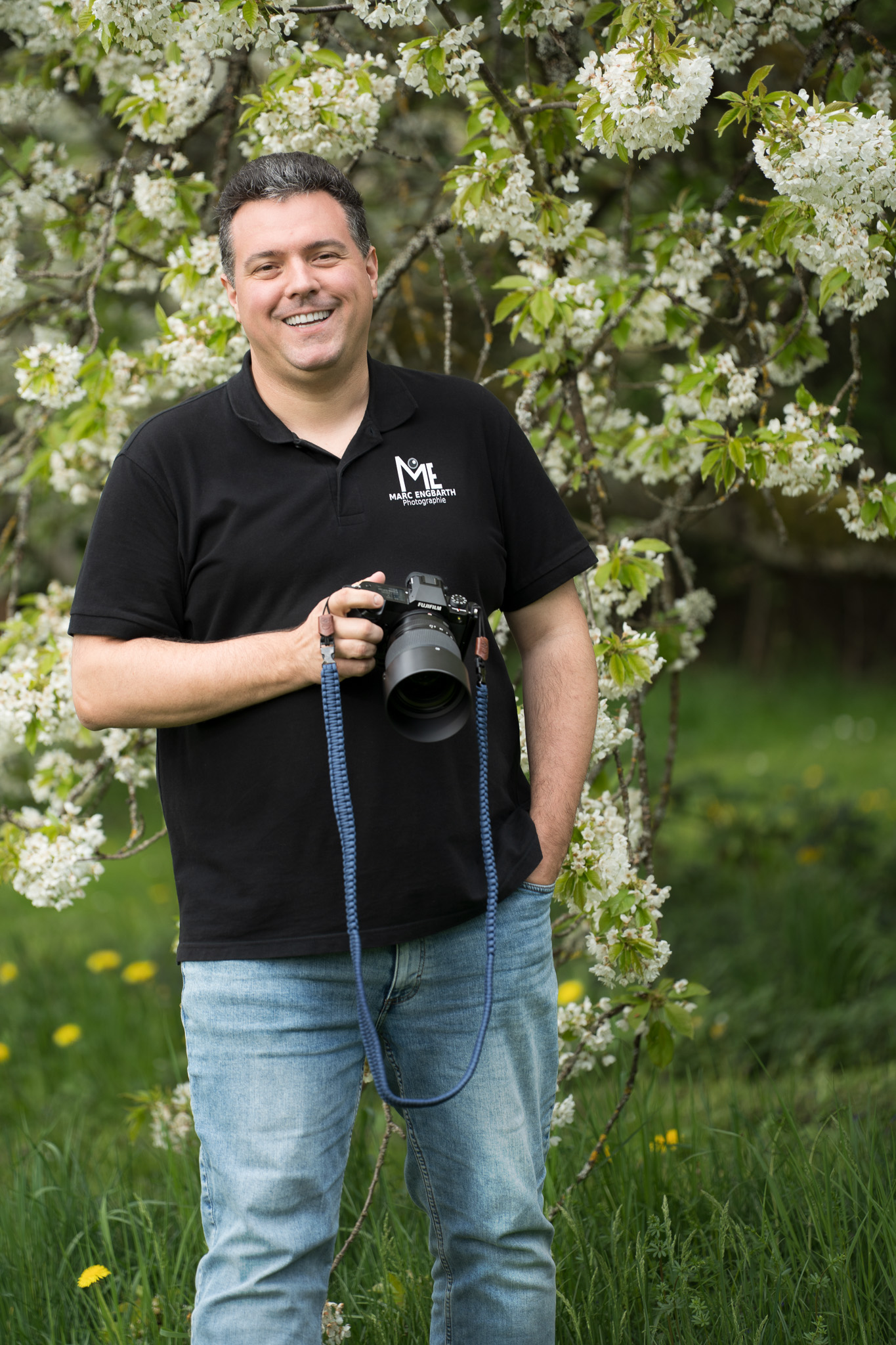 Fotograf Marc Engbarth mit Kamera vor blühendem Baum
